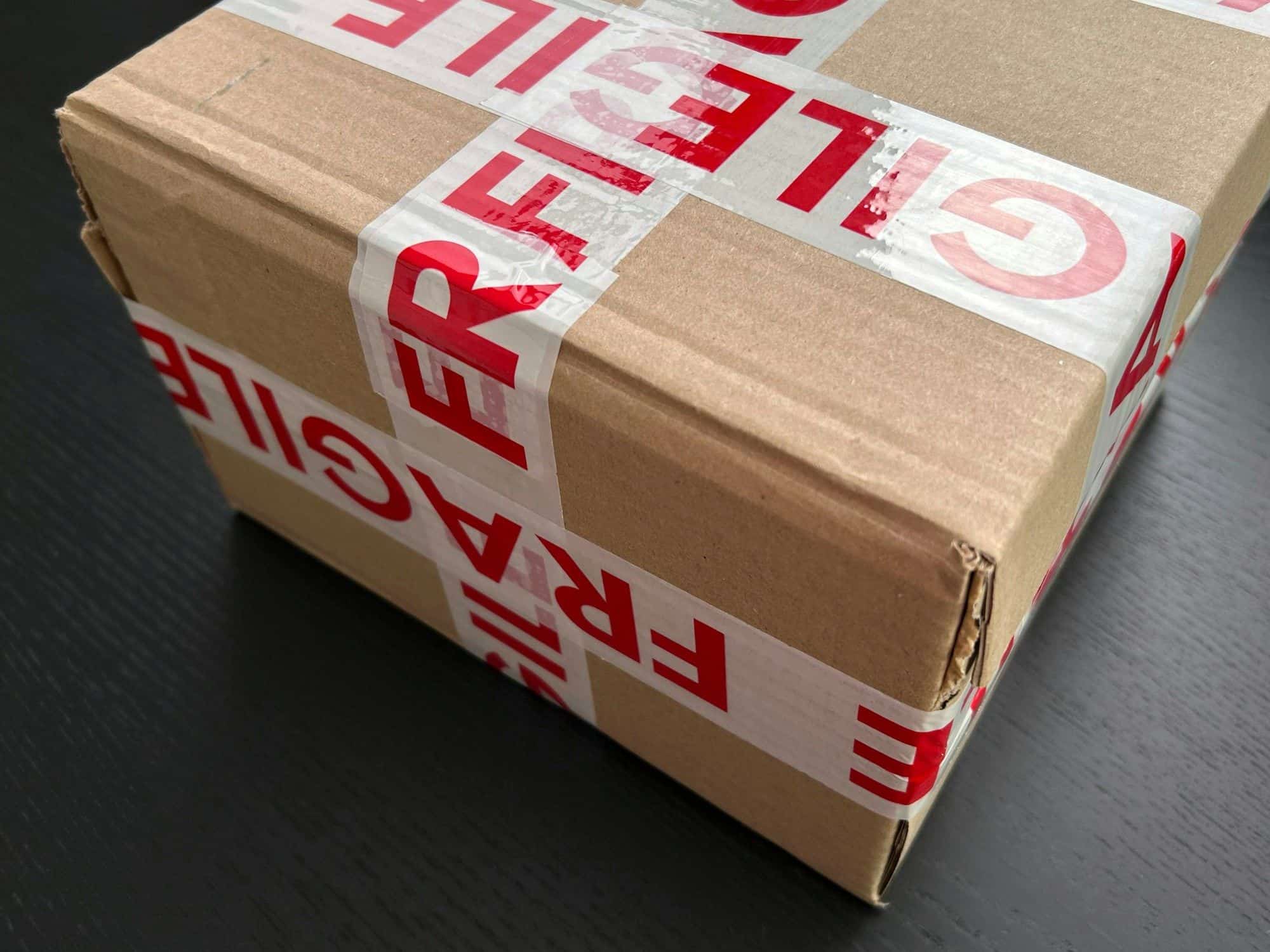 Cardboard carton sealed with red FRAGILE tape