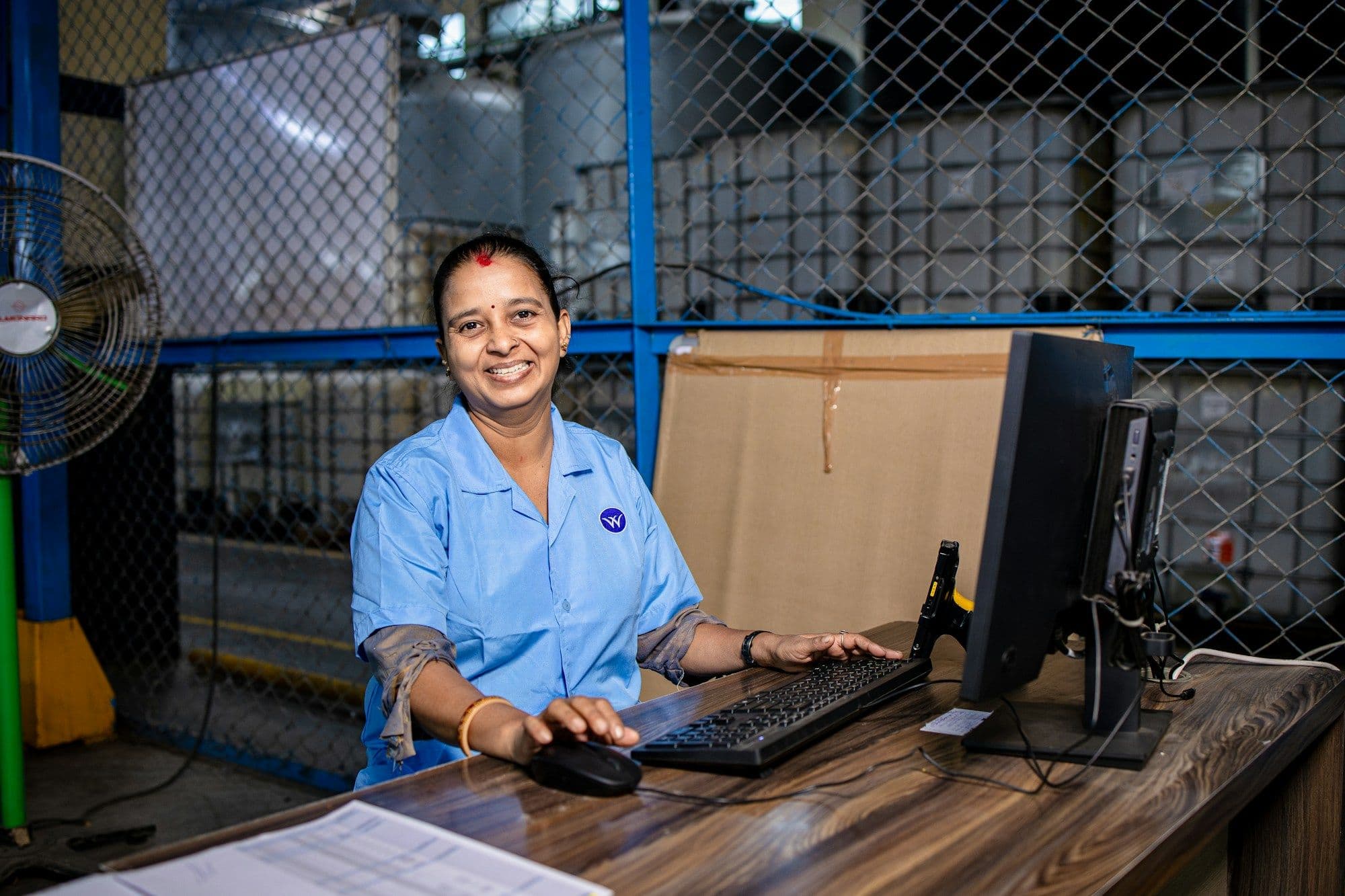 Smiling warehouse team member at her workstation