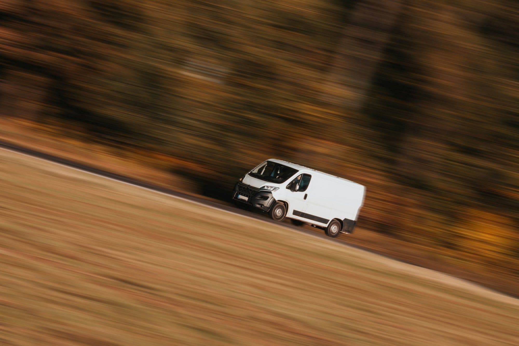 Delivery van speeding along a road, motion-blurred