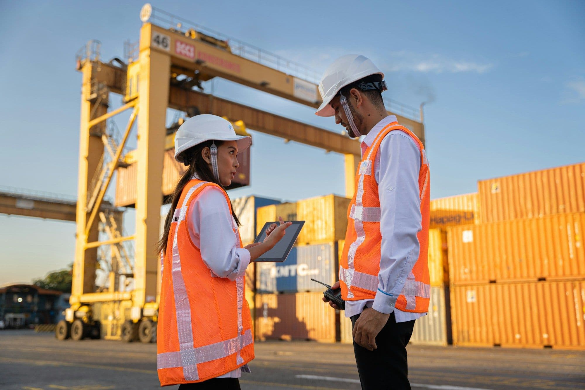 Port officers in high-visibility vests checking shipment details