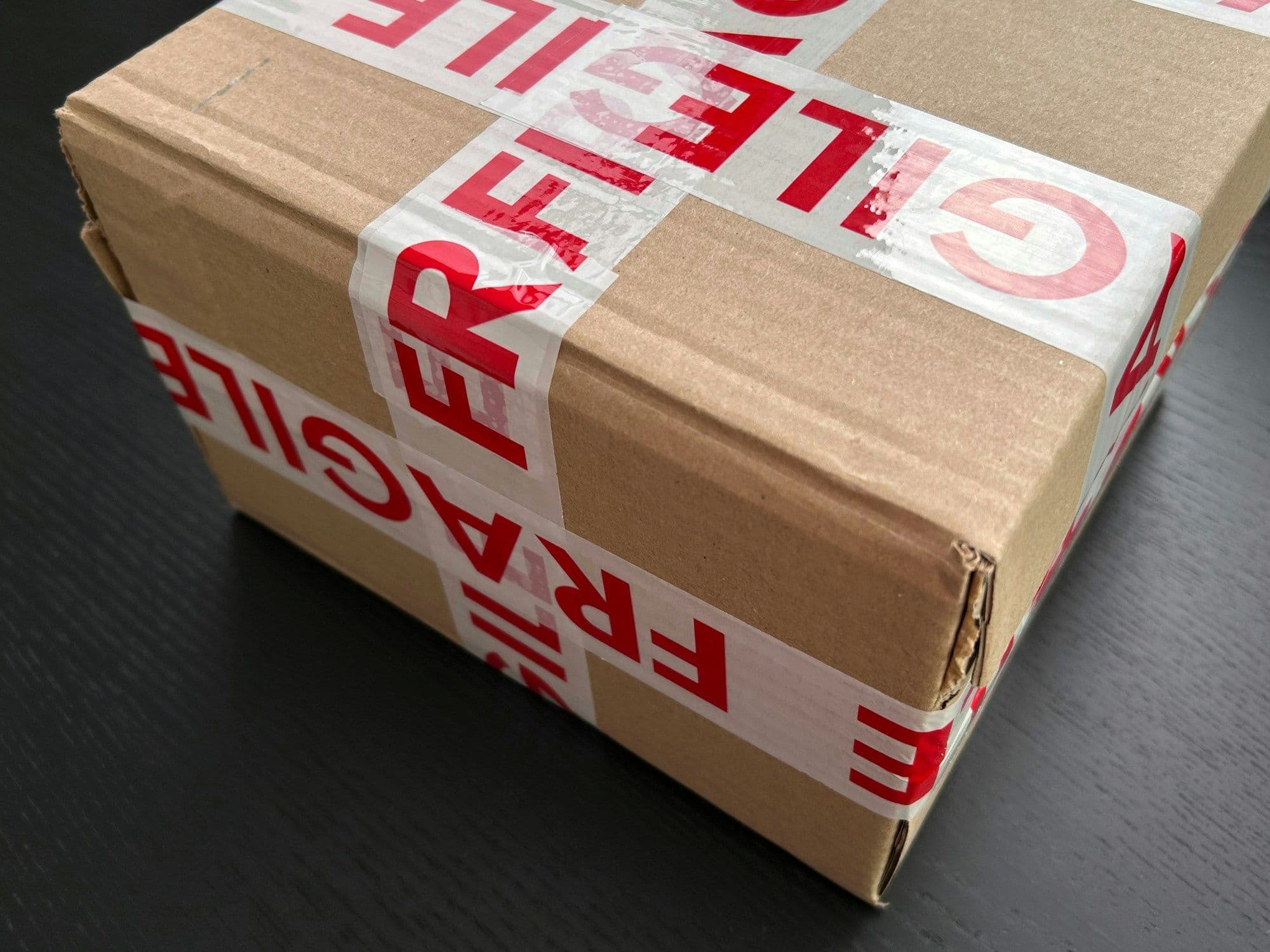 Parcel wrapped in red fragile tape